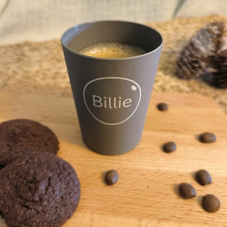 Tasse réemployable Billie 12 avec des biscuits et des grains des café à côté