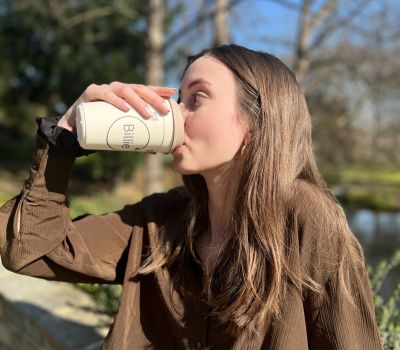 Régalez-vous ! Fille qui boit dans un gobelet réutilisable