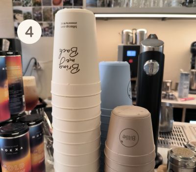 Piles de tasses réutilisables Billie Cup posées sur le comptoir de Café Mokxa à Lyon